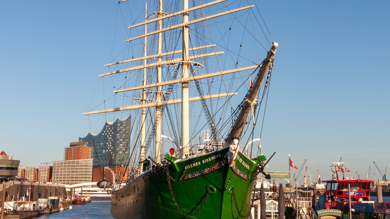 Das Museumsschiff Rickmer Rickmers an den Hamburger Landungsbrücken mit der Elbphilharmonie im Hintergrund bei strahlend blauem Himmel als Titelmotiv für die gynäkologische Fachveranstaltung 3. Hamburger Endometriosetage des Norddeutschen Endometriosezentrums für Ärztinnen, Ärzte und Zuweisende im Albertinen Krankenhaus und online.