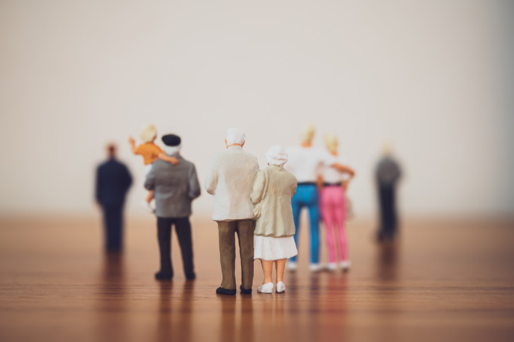 Mehrere Paare und Menschen unterschiedlichen Alters stehen als Miniaturfiguren abgebildet auf einer Fläche aus Holz vor einem unscharfen Horizont als Motiv für das Einführungssymposium "Die Zukunft ist alt – Chancen einer modernen Geriatrie" von Priv.-Doz. Dr. med. Markus Gödel, Chefarzt im Albertinen Zentrum für Altersmedizin im Albertinen Krankenhaus in Hamburg.