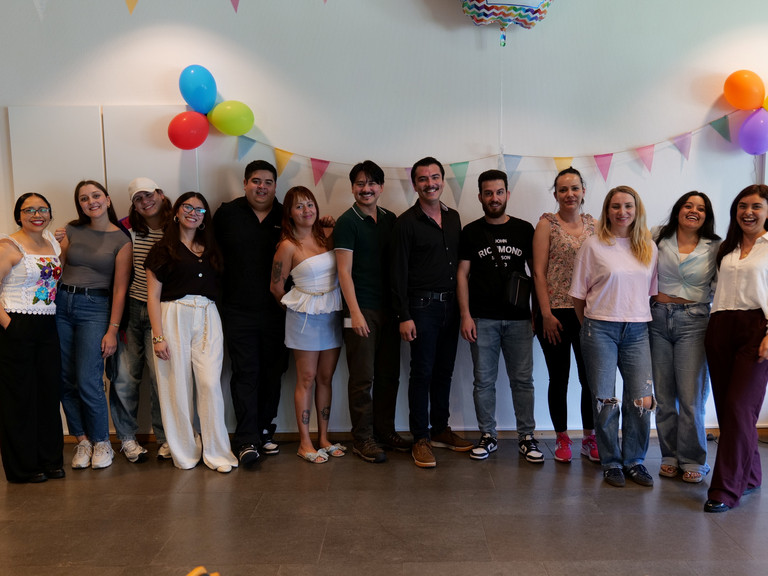 Ein Gruppenfoto internationaler Pflegefachkräfte in einem mit Luftballons bunt geschmückten Veranstaltungsraum bei der Anerkennungsfeier für internationale Pflegefachkräfte im Albertinen Krankenhaus in Hamburg.