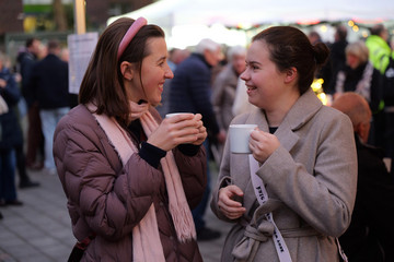 Zwei Besucherinnen unterhalten sich bei Punsch auf dem Weihnachtsmarkt der Immanuel Albertinen Diakonie