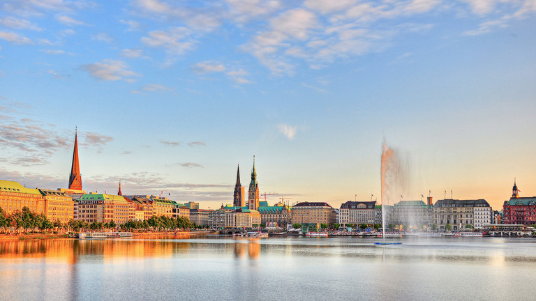 Foto der Binnenalster in Hamburg mit Stadtpanorama bei Sonnenuntergang zur Fachveranstaltung in der Innenstadt "Schnittstelle Gynäkologie - relevante Updates für Praxis und Klinik" der Klinik für Gynäkologie und Geburtshilfe im Albertinen Krankenhaus