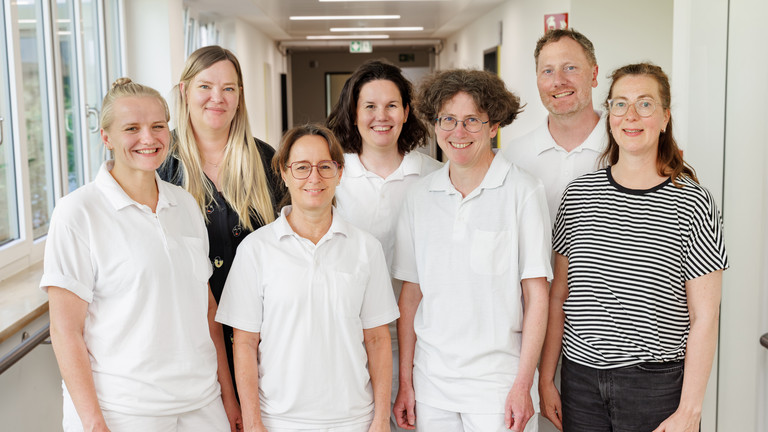 Die Teamleiter des Interdisziplinären Therapiezentrums im Albertinen Krankenhaus in Hamburg Schnelsen stehen auf dem Gang und strahlen in die Kamera
