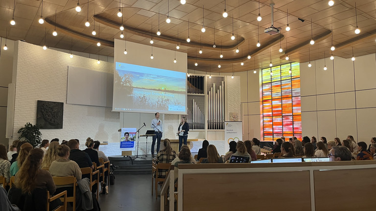 Blick über die Sitzreihen zur Bühne mit Leinwand in der Kirche am Krankenhaus beim zweiten Hamburger Endometriosetag 2025 der Klinik für Gynäkologie und Geburtshilfe im Albertinen Krankenhaus