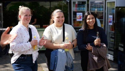 Drei Besucherinnen stehen fröhlich zusammen beim Albertinen-Sommerfest für die Mitarbeitenden aus den unterschiedlichen Einrichtungen der Immanuel Albertinen Diakonie am Standort Schnelsen auf dem Platz vor der Kirche am Albertinen Krankenhaus.