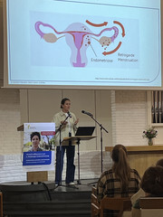 Eine Vortragende steht am Mikrofon vor der Grafik einer Gebärmutter auf einem Beamer beim zweiten Hamburger Endometriosetag 2025 der Klinik für Gynäkologie und Geburtshilfe im Albertinen Krankenhaus