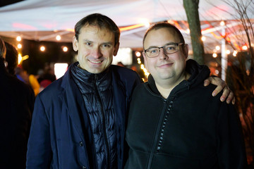 Zwei Besucher des Weihnachtsmarkts der Immanuel Albertinen Diakonie stehen lächelnd am Abend zusammen