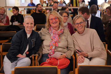 Mitarbeitende der Immanuel Albertinen Diakonie sitzen gut gelaunt in der Kirche des Albertinen Krankenhauses bei der Weihnachtsfeier
