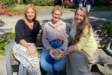 Drei Mitarbeiterinnen des Albertinen Krankenhauses sitzen bei „Let’s have lunch“ gemeinsam im Freien und genießen Kumpir.