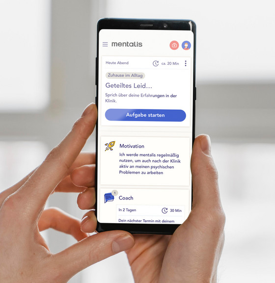 Ein in den Händen gehaltenes Smartphone mit geöffneter Mentalis-App