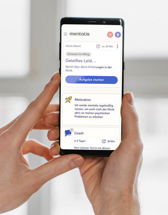 Ein in den Händen gehaltenes Smartphone mit geöffneter Mentalis-App