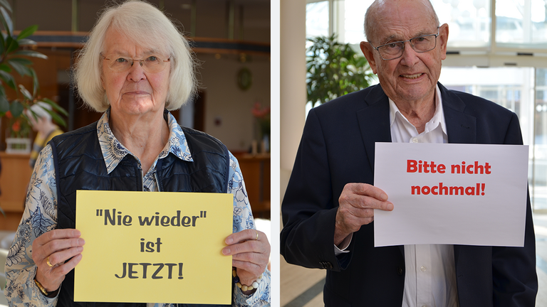 Eine Seniorin und ein Senior aus der Residenz am Wiesenkamp blicken in Kamera und halten ein Schild mit einem Statement gegen rechtsextremistische Entwicklungen in die Kamera