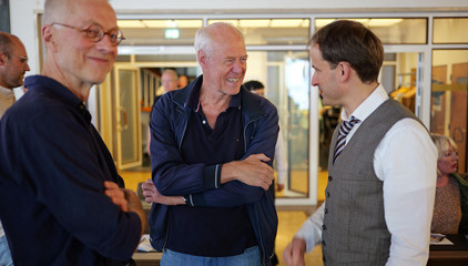 Priv.-Doz. Dr. Gödel, Chefarzt der Klinik für Geriatrie im Albertinen Zentrum für Altersmedizin im Albertinen Krankenhaus in Hamburg, unterhält sich beim Empfang mit zwei Gästen bei seinem Einführungssymposium „Die Zukunft ist alt!“.