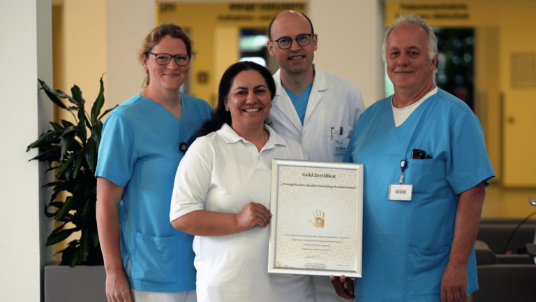 Tina Köpke, Ayse Uslu, Prof. Dr. Ernst von Dobschütz und Jörn Schomacker mit dem Gold-Zerftifikat für hevorragende Handhygiene der Aktion Saubere Hände