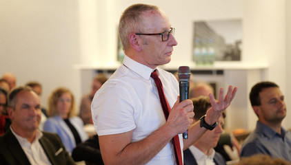 Ralf Zastrau aus dem Albertinen Haus spricht mit einem beim Mikrofon in der Hand beim Einführungssymposium „Die Zukunft ist alt!“ von Priv.-Doz. Dr. Gödel, Chefarzt der Klinik für Geriatrie im Albertinen Zentrum für Altersmedizin im Albertinen Krankenhaus in Hamburg.