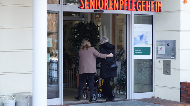 Mandy Schneider aus der Hospizverwaltung begleitet eine Gästin zu Fuß zurück in das Gebäude