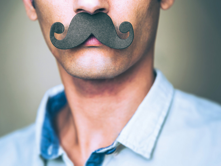 Mann mit großem schwarzen Papier-Schnurrbart als Symbol für die Movember-Aktion zur Männergesundheit des Albertinen Krankenhauses Hamburg und des HSVH.