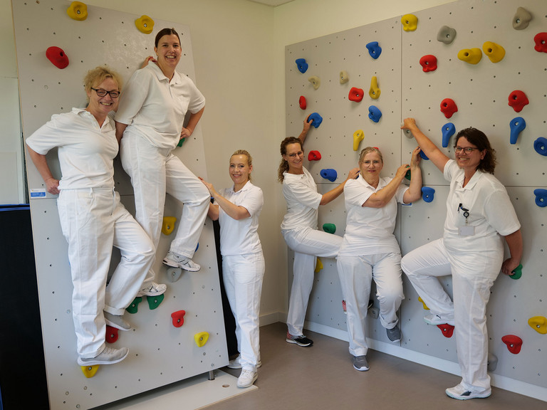 Geriatrie-Team an Kletterwand