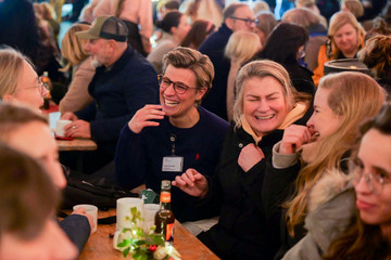 Fröhliche Mitarbeitende der Immanuel Albertinen Diakonie lachen und unterhalten sich auf dem Weihnachtsmarkt