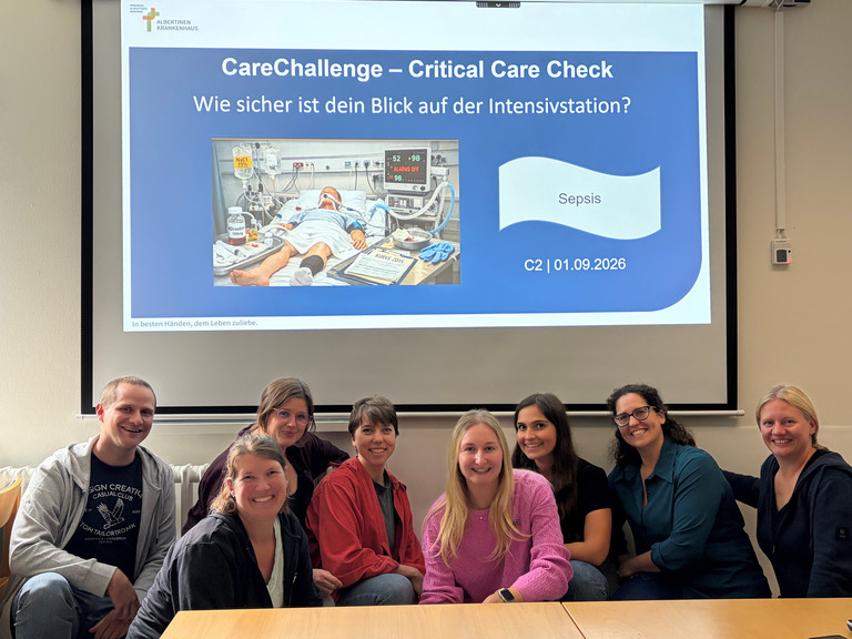 Teilnehmende der CareChallenge im Albertinen Krankenhaus vor einer Präsentation zum Thema Sepsis und Patientensicherheit auf der Intensivstation.