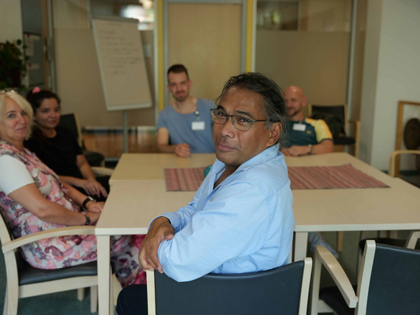 Ein Mitarbeiter blickt in die Kamera an einem Tisch mit mehreren Personen im Hintergrund bei einer Besprechung in der Klinik für Psychiatrie und Psychotherapie im Albertinen Krankenhaus in Hamburg.